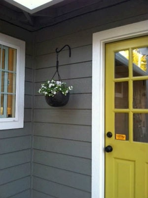 exterior of grey home with a yellow door