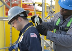 worker connecting safety gear to another worker