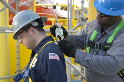worker connecting safety gear on another worker