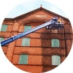 Modern Painting worker on lift power washing building