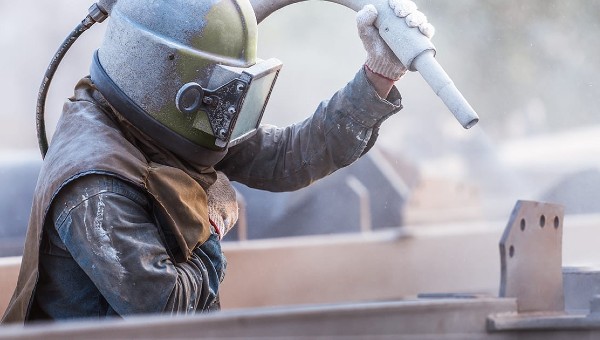 Worker in protective gear doing commercial blasting service Worker in protective gear doing commercial blasting service