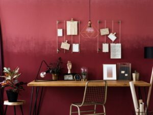 A working desk rested against a dark red wall.