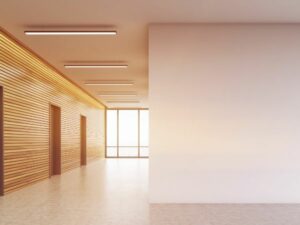 A lobby with elevators and a light pink wall