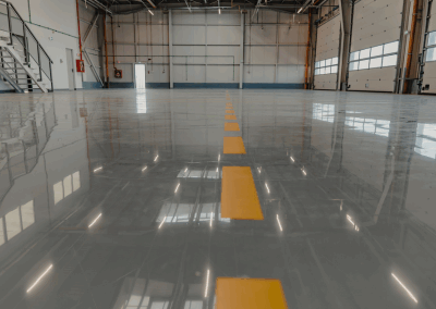 a shiny epoxy floor in a airport hanger with yellow safety striping