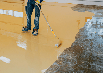 an employee applying a yellow epoxy floor