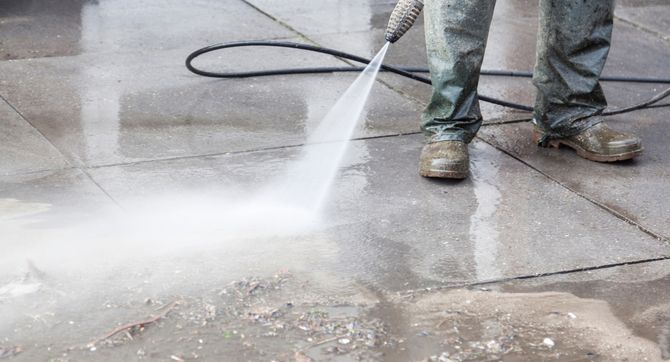a crew member pressure washing the sidewalk in front of a retail store in Hilliard, Ohio
